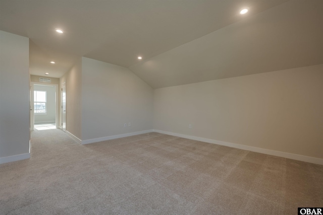 additional living space featuring vaulted ceiling, recessed lighting, baseboards, and light colored carpet