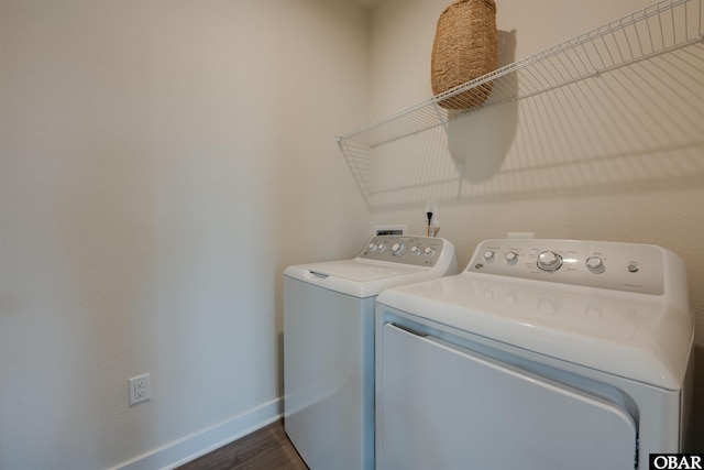 washroom featuring dark wood-type flooring, laundry area, baseboards, and washing machine and clothes dryer