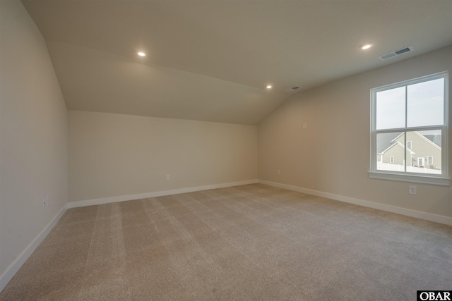 additional living space with lofted ceiling, visible vents, baseboards, and recessed lighting