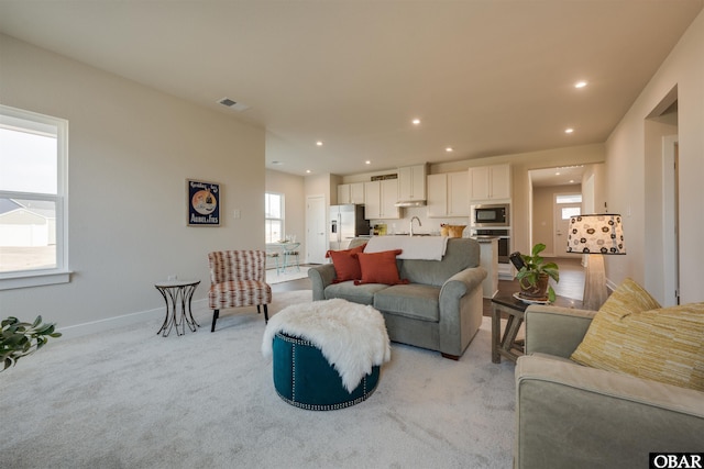 living room with baseboards, light colored carpet, visible vents, and recessed lighting