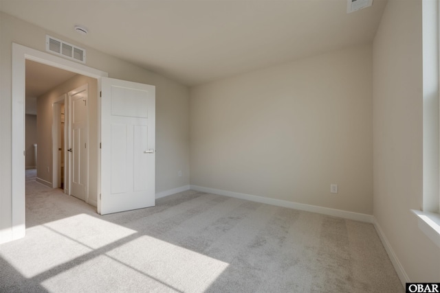 unfurnished room featuring baseboards, visible vents, and light colored carpet