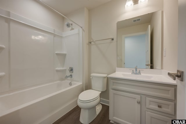 bathroom featuring visible vents, toilet, wood finished floors, vanity, and shower / washtub combination