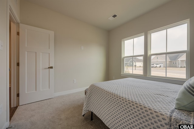 bedroom featuring carpet floors, visible vents, and baseboards