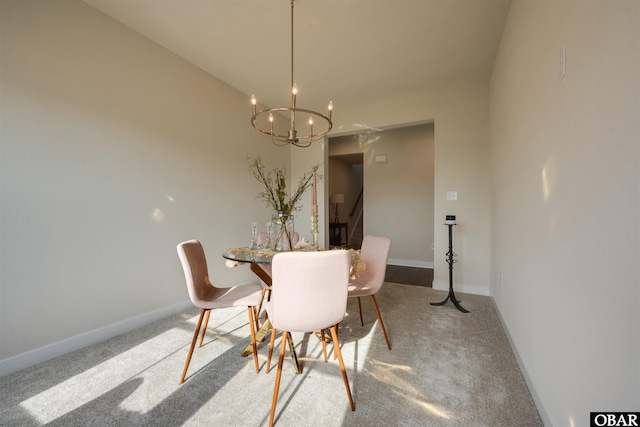 dining area with carpet, baseboards, and a chandelier