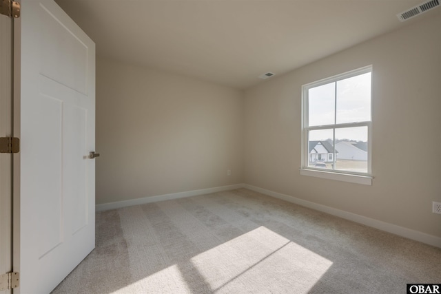 carpeted empty room with visible vents and baseboards