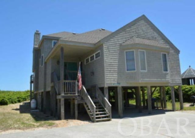 raised beach house featuring driveway and a carport