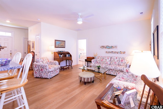 living area with visible vents, light wood finished floors, and a ceiling fan