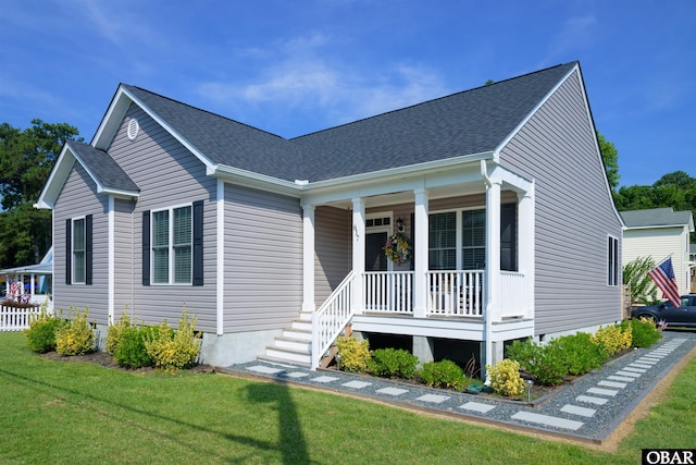 view of front of property featuring covered porch, a shingled roof, and a front lawn