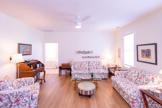 living room with a ceiling fan, visible vents, and light wood-style flooring