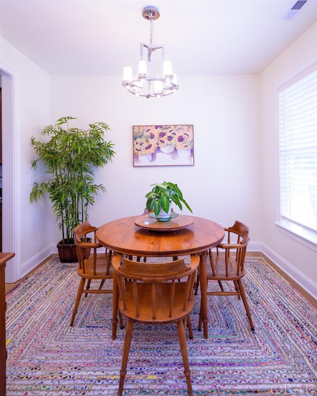 dining area featuring baseboards, visible vents, and a chandelier