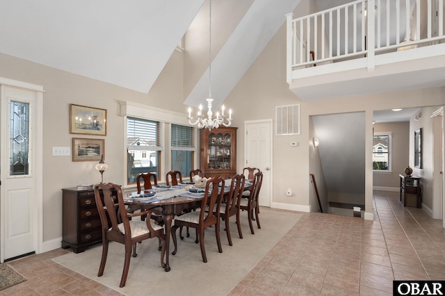 tiled dining area featuring a notable chandelier, visible vents, high vaulted ceiling, and baseboards