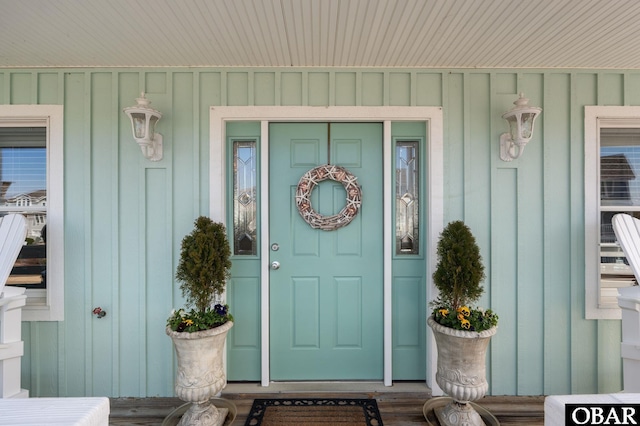 doorway to property with a porch and board and batten siding