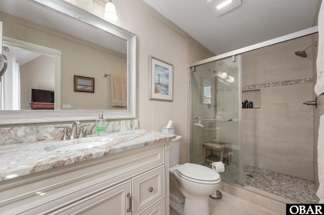 bathroom with tile patterned flooring, a shower stall, toilet, and vanity