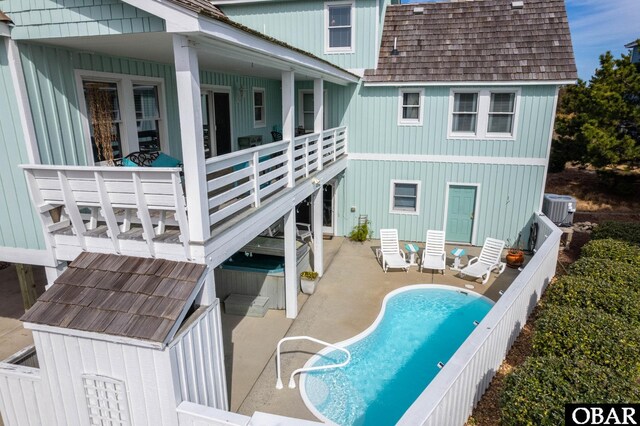 back of property with mansard roof, a patio, roof with shingles, and central AC