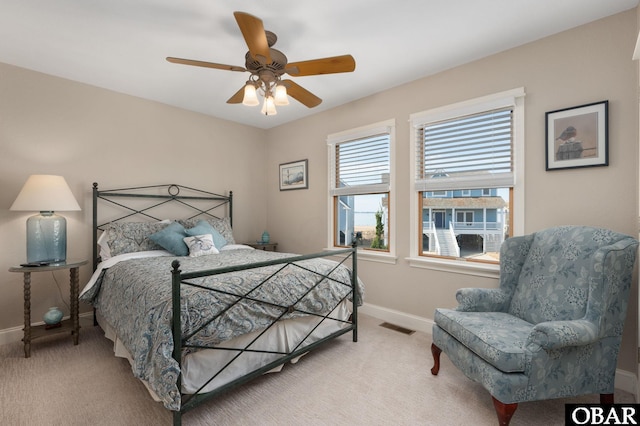 carpeted bedroom with baseboards, visible vents, and ceiling fan