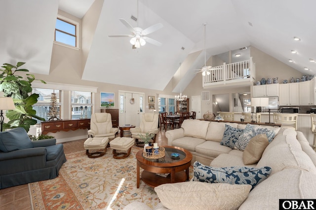 tiled living room featuring visible vents, a high ceiling, and ceiling fan with notable chandelier