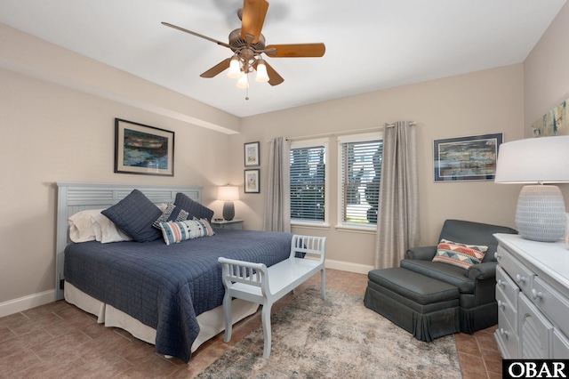 tiled bedroom featuring a ceiling fan and baseboards