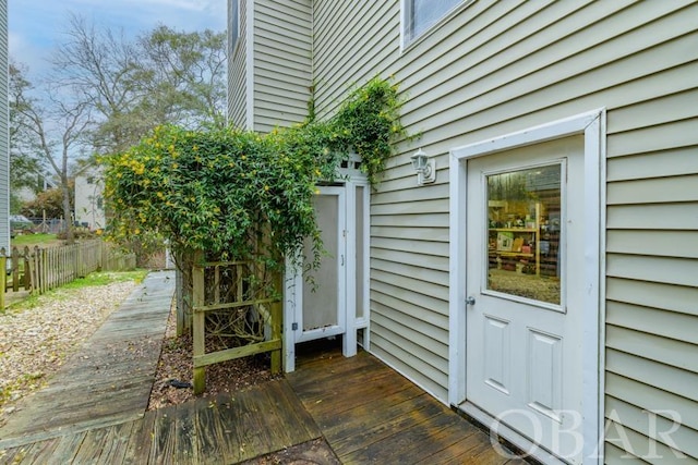 entrance to property with a deck and fence