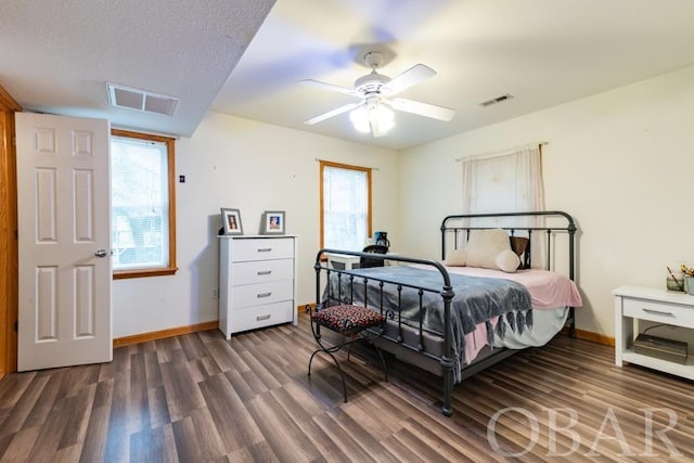 bedroom with baseboards, multiple windows, visible vents, and dark wood-style flooring