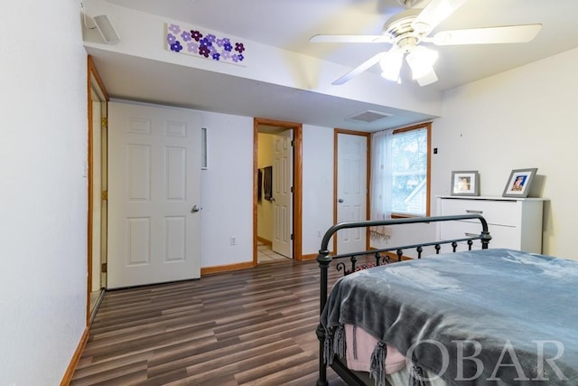 bedroom with dark wood-style floors, visible vents, a ceiling fan, and baseboards