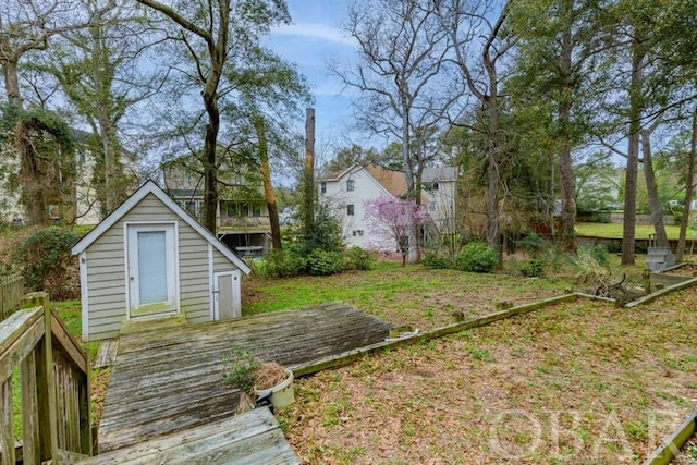 view of yard featuring an outbuilding, a deck, and a storage unit