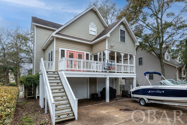 back of house featuring a garage and stairs