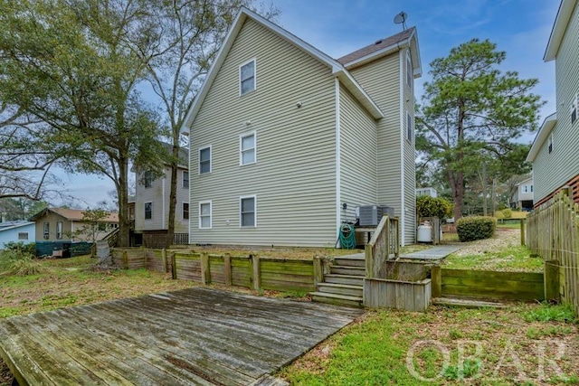 back of property with fence private yard, a wooden deck, and stairs