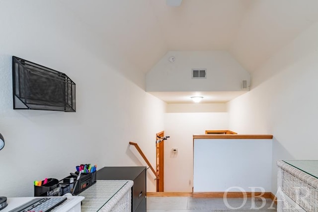 interior space with visible vents, vaulted ceiling, and an upstairs landing