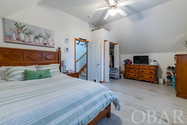 bedroom with light wood-type flooring, a closet, vaulted ceiling, and ceiling fan