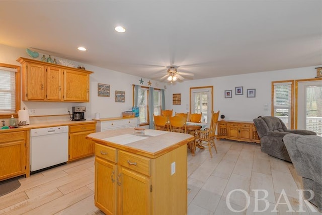 kitchen featuring recessed lighting, light wood-style flooring, open floor plan, a kitchen island, and white dishwasher