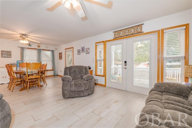 living room featuring a ceiling fan, french doors, and light wood-style flooring