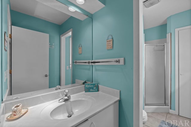 full bathroom featuring toilet, a stall shower, vanity, and tile patterned floors