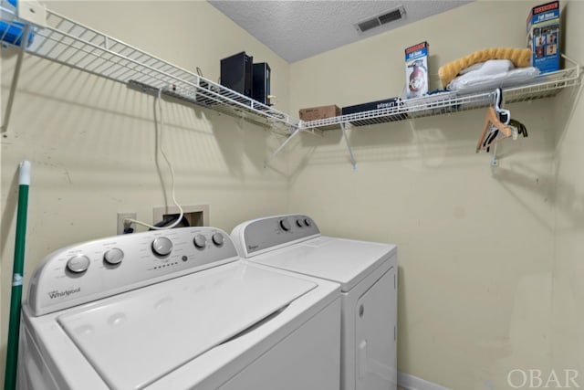 laundry area with a textured ceiling, laundry area, separate washer and dryer, and visible vents