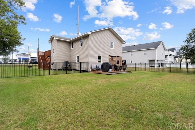 rear view of property with a fenced backyard, a lawn, and stairway