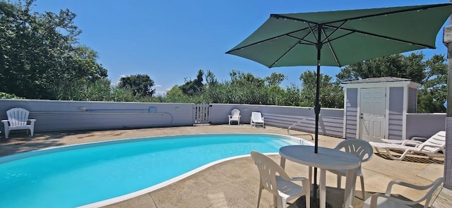 view of swimming pool featuring a fenced in pool, an outbuilding, and a patio area