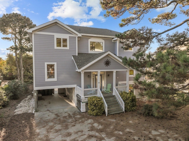 beach home with covered porch, concrete driveway, roof with shingles, stairway, and a carport