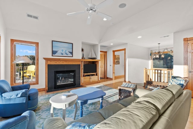 living room with vaulted ceiling, a fireplace, visible vents, and recessed lighting