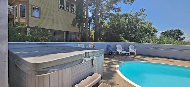 view of swimming pool featuring a hot tub