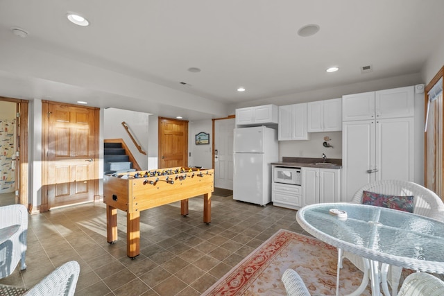 rec room featuring dark tile patterned floors, visible vents, a sink, and recessed lighting