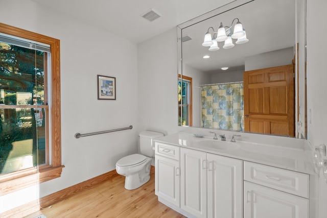 full bath with baseboards, visible vents, toilet, wood finished floors, and vanity