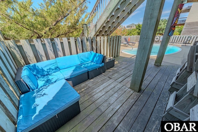 deck with a fenced backyard, a community pool, and outdoor lounge area