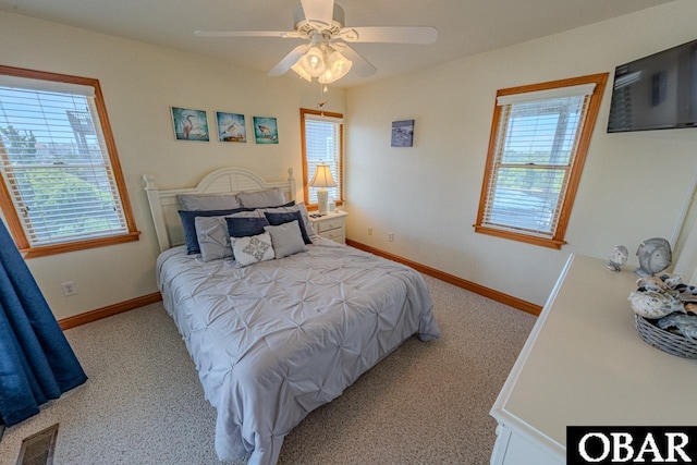 bedroom featuring light colored carpet, multiple windows, and baseboards