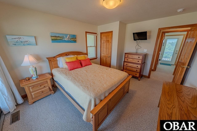 bedroom featuring light colored carpet, visible vents, and baseboards