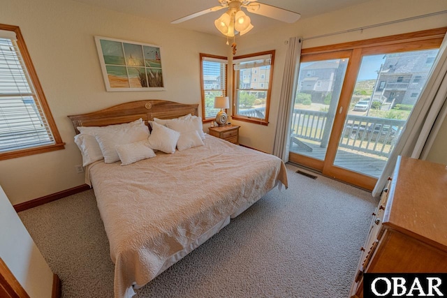 carpeted bedroom with access to exterior, baseboards, multiple windows, and visible vents