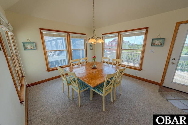 dining area featuring light carpet, baseboards, and an inviting chandelier