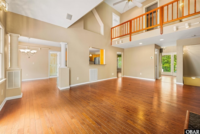 4 Birch Ln Lot 15, Southern Shores, NC 27949 - unfurnished living room featuring a chandelier, hardwood / wood-style flooring, ornate columns, ceiling fan, and a towering ceiling