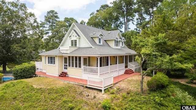 4 Birch Ln Lot 15, Southern Shores, NC 27949 - view of front facade featuring a shingled roof, a front yard, a porch, and view of scattered trees