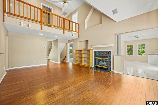 4 Birch Ln Lot 15, Southern Shores, NC 27949 - unfurnished living room featuring a ceiling fan, a high end fireplace, wood finished floors, stairs, and a high ceiling