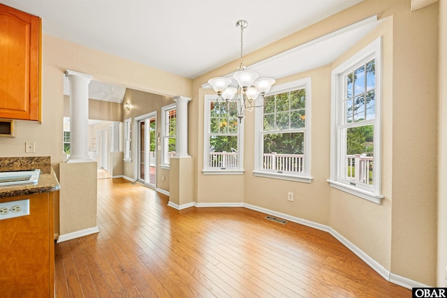 4 Birch Ln Lot 15, Southern Shores, NC 27949 - unfurnished dining area featuring ornate columns, light wood-type flooring, and a chandelier
