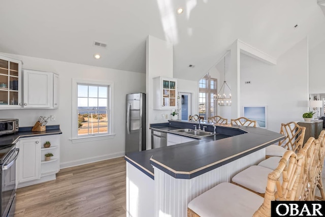 54053 Sandpiper Dr Lot 4, Frisco, NC 27936 - kitchen featuring stainless steel appliances, dark countertops, a sink, vaulted ceiling, and a breakfast bar